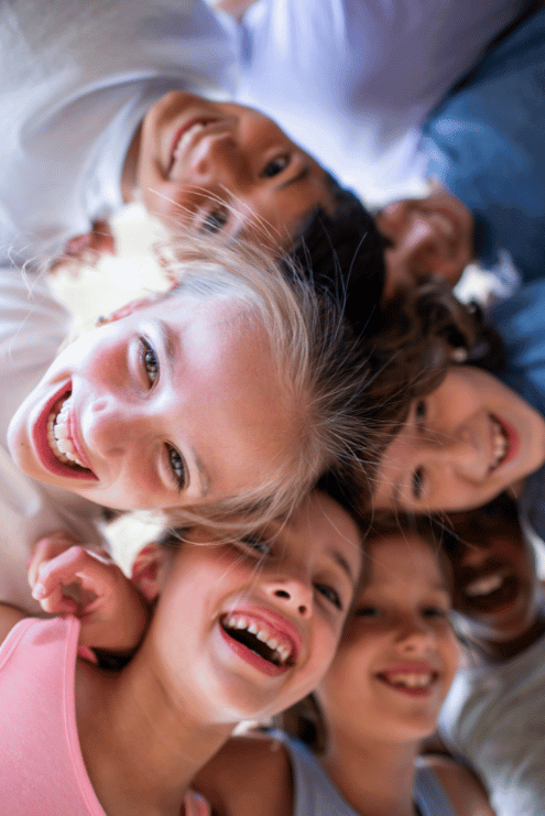 Children in a circle laughing looking down at the camera at charlie park atherton