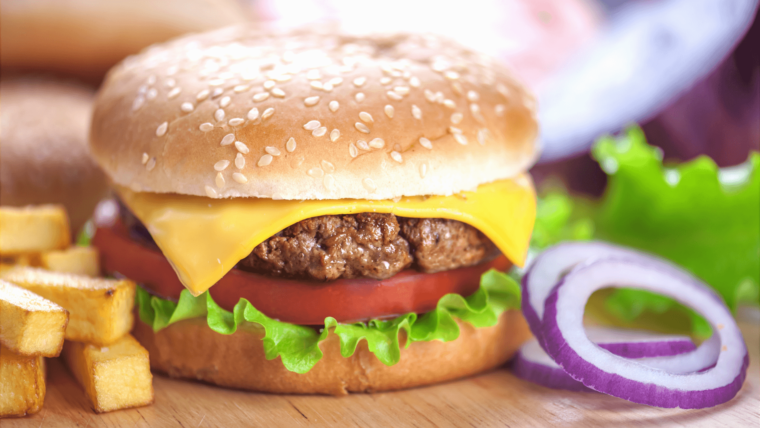 a hamburger and french fries on a cutting board