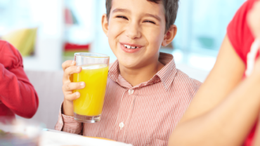 happy child drinking orange juice