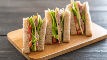 triangle sandwiches on a wooden platter
